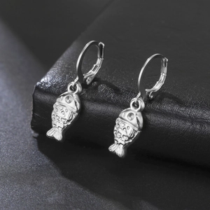 Macro shot of silver stainless steel fish earrings with detailed scales and secure hoops
