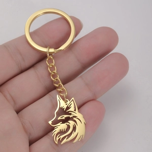 Golden 304 stainless steel wolf head keychain with hollow design held in hand