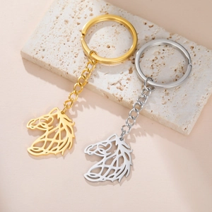 Polished hollow horse head keychains in gold and silver finish on a textured background
