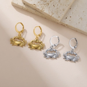 Macro shot of crab pendants on leverback hoops in polished gold and silver steel finish