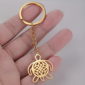 Detailed close-up of golden sea turtle keychain with intricate celtic pattern