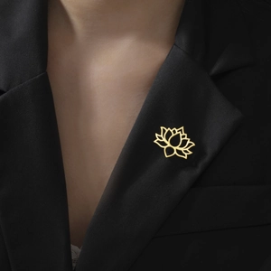 Detail of a gold lotus brooch with hollow lines pinned on a black suit lapel