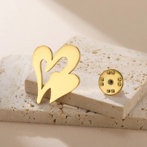 Detail of minimalist gold double heart brooch with textured butterfly clutch backing