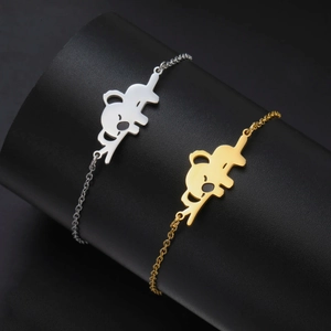 Detail van schattige koala-hangers in goud en zilver op roestvrijstalen armbanden