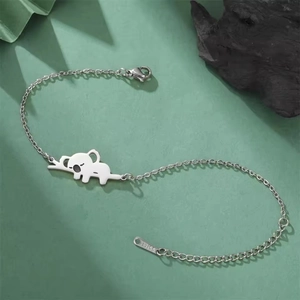 Macrodetail van zilveren koala bedelarmband met karabijnsluiting op een natuurlijke achtergrond