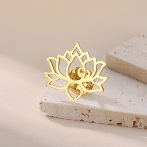 Detailed view of a golden lotus brooch with hollow lines on a stone block surface