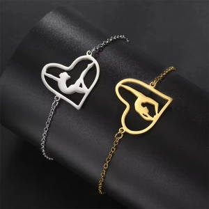 Gold and silver stainless steel gymnast heart bracelets on a black leather display stand
