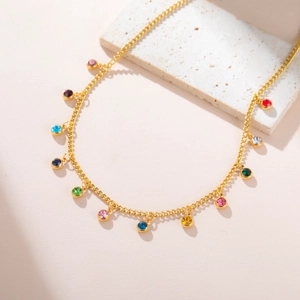 Detailed macro of gold-plated necklace featuring twelve colorful rainbow zircon pendants