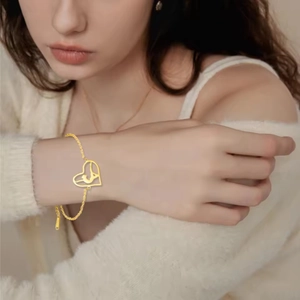 Gold stainless steel heart pendant bracelet with Arabic calligraphy on female wrist