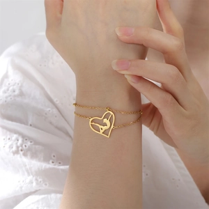 Detailed shot of double-layer gold heart bracelet with rhythmic gymnast silhouette charm