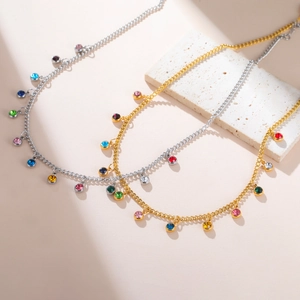 Close-up of gold and silver necklaces with colorful round zircon gemstone pendants
