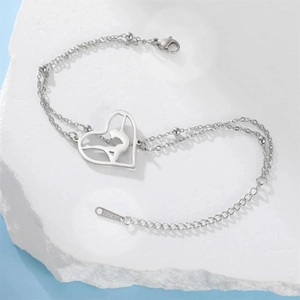 Detail of silver stainless steel heart gymnast bracelet on white stone platform