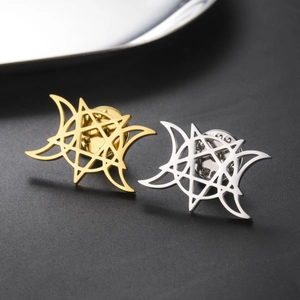 Macro shot of gold and silver hexagram star and crescent brooches on a dark textured surface