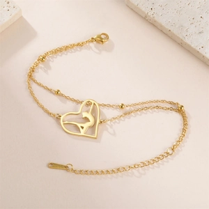 Detailed close-up of double-layer stainless steel gold chain bracelet with cat heart pendant