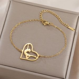 Macro shot of a gold stainless steel bracelet with a gymnast silhouette heart pendant