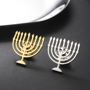 Macro shot of gold and silver Menorah brooches on a textured black premium background