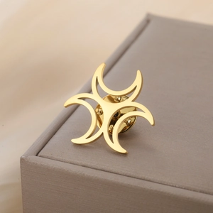 Detailed macro view of a golden stainless steel triple moon brooch with butterfly clutch