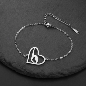 Detailed macro view of silver stainless steel heart gymnast pendant on a fine link chain