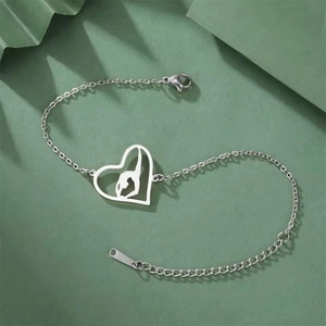 Macro detail of stainless steel heart bracelet with gymnast pendant and lobster clasp