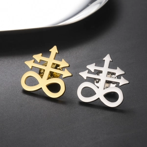 Detail view of gold and silver Leviathan Cross pins on a dark textured background