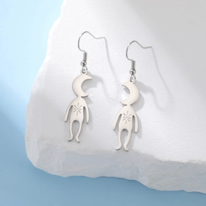 Macro shot of silver alien planet earrings on a white stone with a blue background
