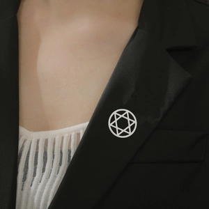 Close-up of the silver stainless steel Hexagram brooch on a black suit lapel