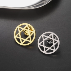 Detailed macro view of gold and silver hexagram brooches with metal butterfly clasps