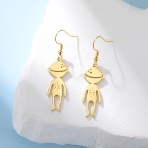 Detailed view of gold stainless steel alien earrings with star engraving on white stone