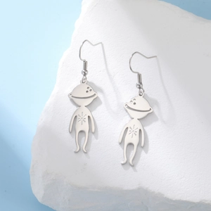 Detail of silver alien drop earrings with star engraving on natural white stone base