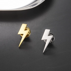Detailed view of lightning bolt pins in gold and silver finishes with butterfly clasps