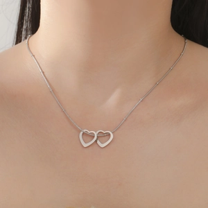 Détail du pendentif double cœurs entrelacés sur chaîne serpent porté par un mannequin