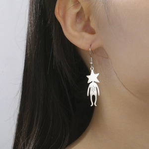 Detail view of cute 304 stainless steel star man pendant earring worn on a model