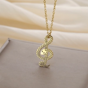 Detailopname van gouden vioolsleutel slang hanger met fijne schubben textuur op de ketting