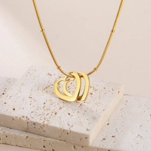 Détail de la chaîne serpent en acier doré avec trois pendentifs en forme de coeur