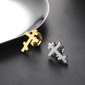 Close-up of gold and silver Orthodox cross pins with secure butterfly clutch backings