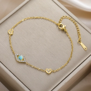 Golden stainless steel evil eye bracelet featuring turquoise inlay and crystal hearts
