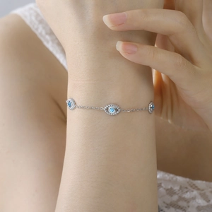 Silver stainless steel evil eye bracelet with blue stones on a woman's wrist