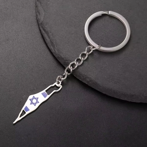 Gros plan du porte-clés carte d'Israël en acier inoxydable avec motif drapeau sur pierre