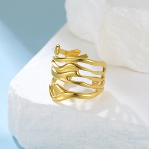Dettaglio degli strati ondulati irregolari e dell'elemento a cuore sull'anello in oro 18K