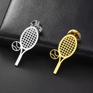 Detail view of silver and gold tennis racket pins with textured leather background