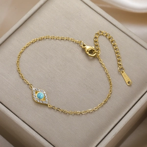 Detailed macro view of S.STEEL hallmark on gold evil eye bracelet with blue stones