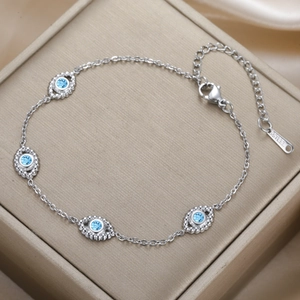 Detailed view of stainless steel bracelet featuring blue evil eye charms and lobster clasp