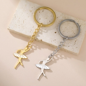 Porte-clés ballerine élégant en or et argent avec robe en émail blanc sur socle
