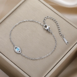 Detail view of silver stainless steel evil eye bracelet on a luxury gift box