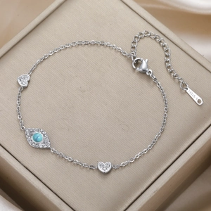 Detailed close-up of a silver stainless steel evil eye bracelet with blue stones