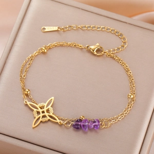Close-up of golden stainless steel bracelet with purple stones and Celtic knot pendant