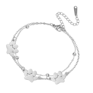 Detail van een zilveren dubbellaagse roestvrijstalen armband met pootafdruk-bedeltjes en kralen