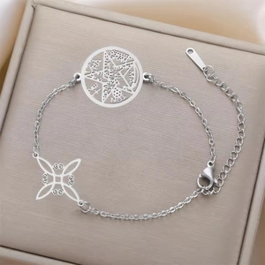 Detailed close-up of stainless steel charms with pentagram and witch knot on a jewelry box