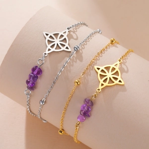 Detailed view of silver and gold stainless steel bracelets with purple crystal beads