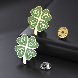Detailed macro view of green enamel four-leaf clover pins with intricate celtic knots